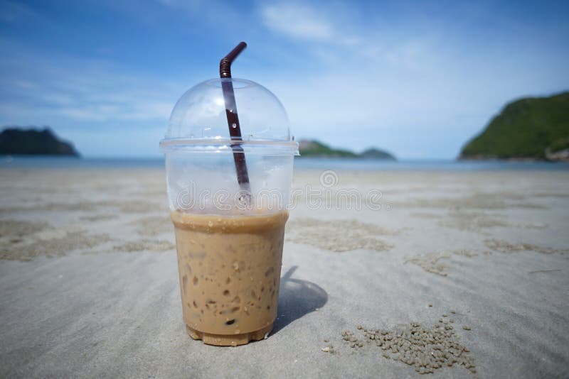 Eine Schale gefrorener Kaffee auf einem Sand mit Unschärfemeer- und -insel backgroud bei Prachuapkhirikhan Thailand lizenzfreie stockfotografie Eine Schale gefrorener Kaffee auf einem Sand mit Unschärfemeer- und -insel backgroud bei Prachuapkhirikhan Thailand lizenzfreie stockfotografie