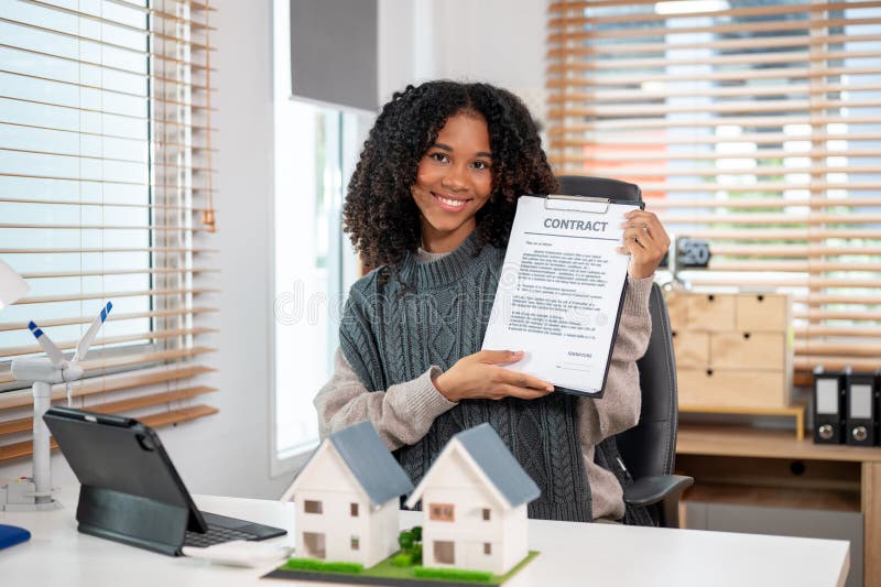 Eine selbstbewusste schwarze Immobilienmaklerin, die ihren Kunden während der Sitzung den Vertrag zeigt lizenzfreies stockbild