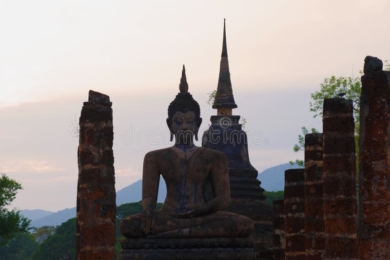 Eine Statue von einem Sitz-Buddha auf den Ruinen des Wat Chana Songkram-Tempels in der Abenddämmerung Sukhothai, Thailand lizenzfreie stockfotos Eine Statue von einem Sitz-Buddha auf den Ruinen des Wat Chana Songkram-Tempels in der Abenddämmerung Sukhothai, Thailand lizenzfreie stockfotos