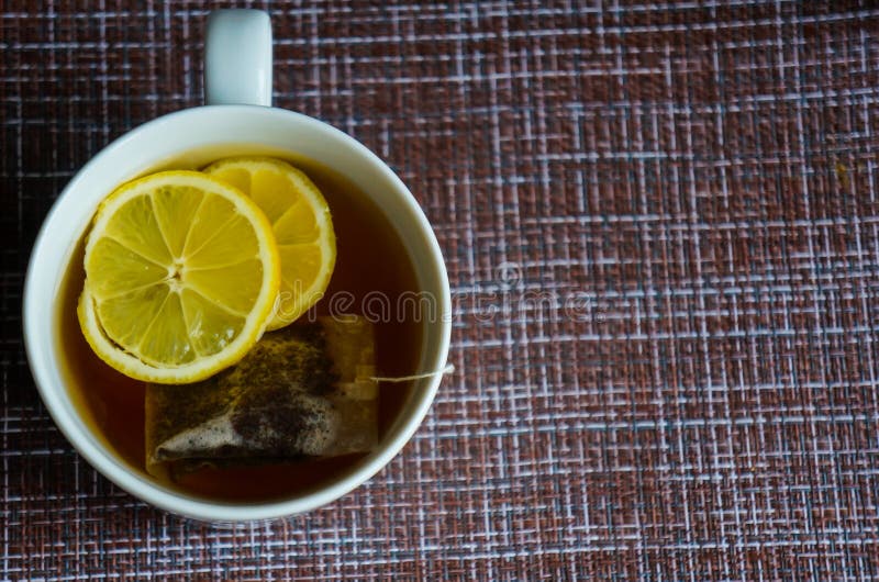 Eine Tasse schwarzer starker Tee mit Zitronen- und Teebeutel lizenzfreie stockfotografie