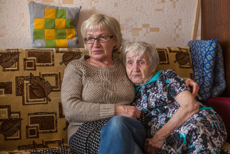 Eine ältere Frau mit ihrer erwachsenen Tochter, welche im Fernsehen die Nachrichten aufpasst familie stockbild Eine ältere Frau mit ihrer erwachsenen Tochter, welche im Fernsehen die Nachrichten aufpasst familie stockbild