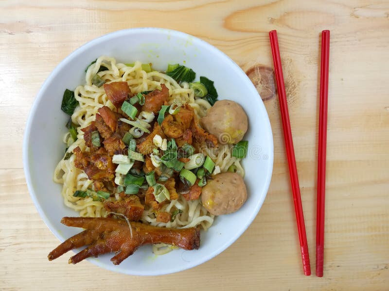Einfaches Foto, flache Lage, köstliches Mie Ayam-ceker bakso, Hühnernudel an der weißen Schüssel und rotes Plastikessstäbchen am stockbild Einfaches Foto, flache Lage, köstliches Mie Ayam-ceker bakso, Hühnernudel an der weißen Schüssel und rotes Plastikessstäbchen am stockbild