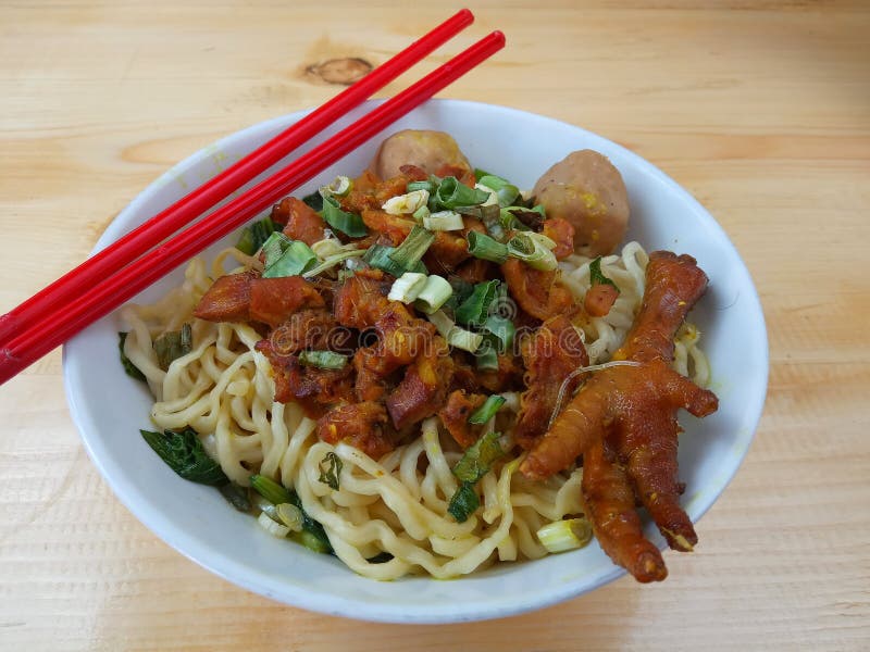 Einfaches Foto, flache Lage, köstliches Mie Ayam-ceker bakso, Hühnernudel an der weißen Schüssel und rotes Plastikessstäbchen am stockfotografie Einfaches Foto, flache Lage, köstliches Mie Ayam-ceker bakso, Hühnernudel an der weißen Schüssel und rotes Plastikessstäbchen am stockfotografie