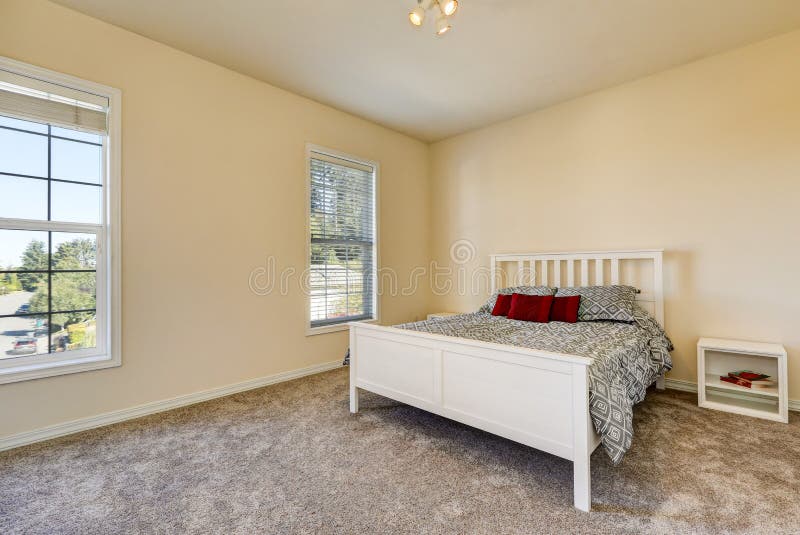 Simple upstairs bedroom with soft peach walls, gray carpet and white wooden bed. Northwest, USA. Simple upstairs bedroom with soft peach walls, gray carpet and white wooden bed. Northwest, USA