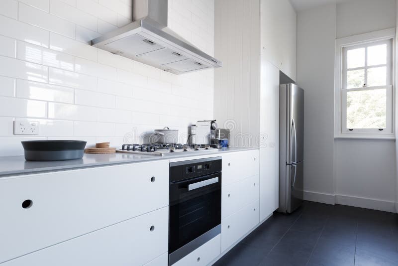 Einfarbiges sauberes weißes Küche benchtop mit Geräten lizenzfreie stockbilder Einfarbiges sauberes weißes Küche benchtop mit Geräten lizenzfreie stockbilder