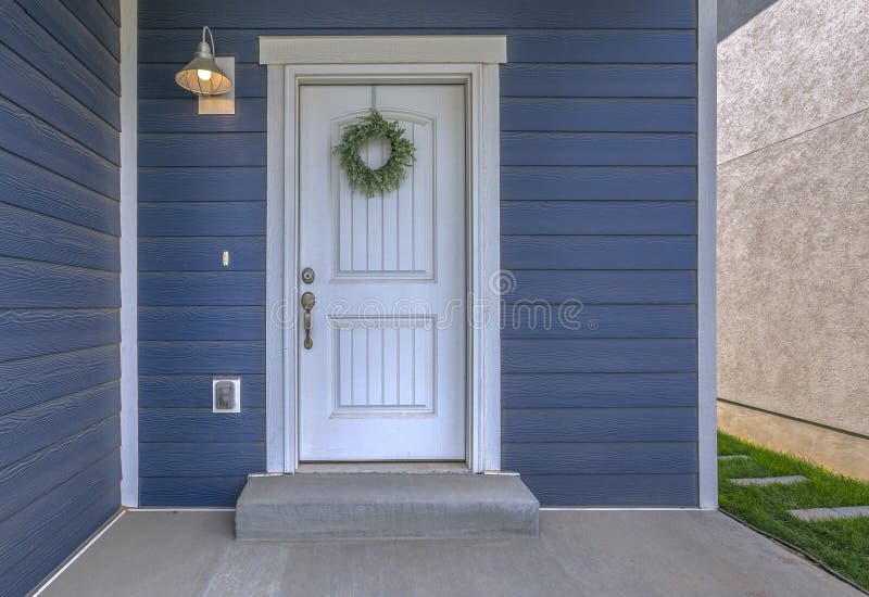 Eingang eines Hauses mit blauer Wand und weißer Tür
