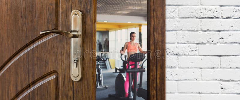 Eingang zur Turnhalle im Fitness-Club, geöffnete Tür mit Frau auf elliptischem Trainer stockfotografie Eingang zur Turnhalle im Fitness-Club, geöffnete Tür mit Frau auf elliptischem Trainer stockfotografie