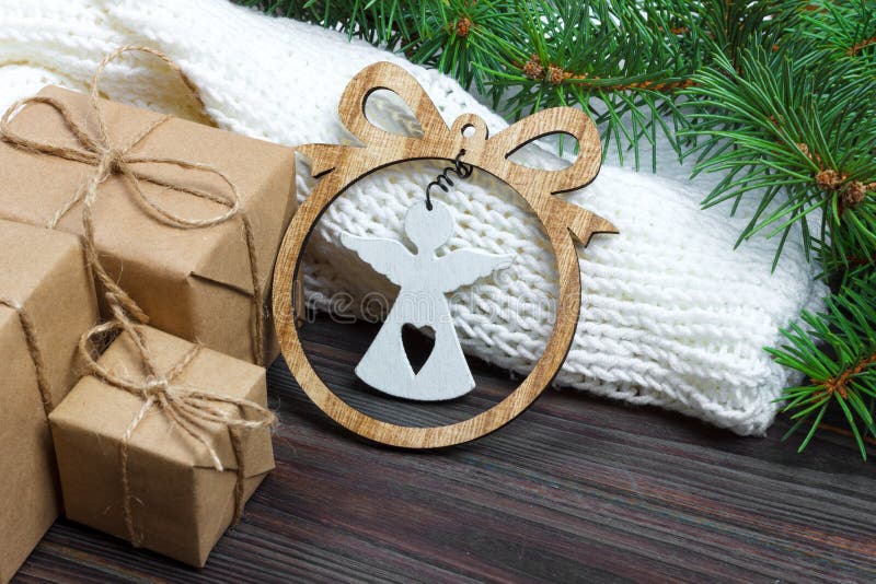 Eingewickelte Weihnachtsgeschenke mit weißem Engel auf dunklem rustikalem Holztisch mit Kiefernkegeln und -Tannenzweigen Mit Kopi stockfotografie Eingewickelte Weihnachtsgeschenke mit weißem Engel auf dunklem rustikalem Holztisch mit Kiefernkegeln und -Tannenzweigen Mit Kopi stockfotografie