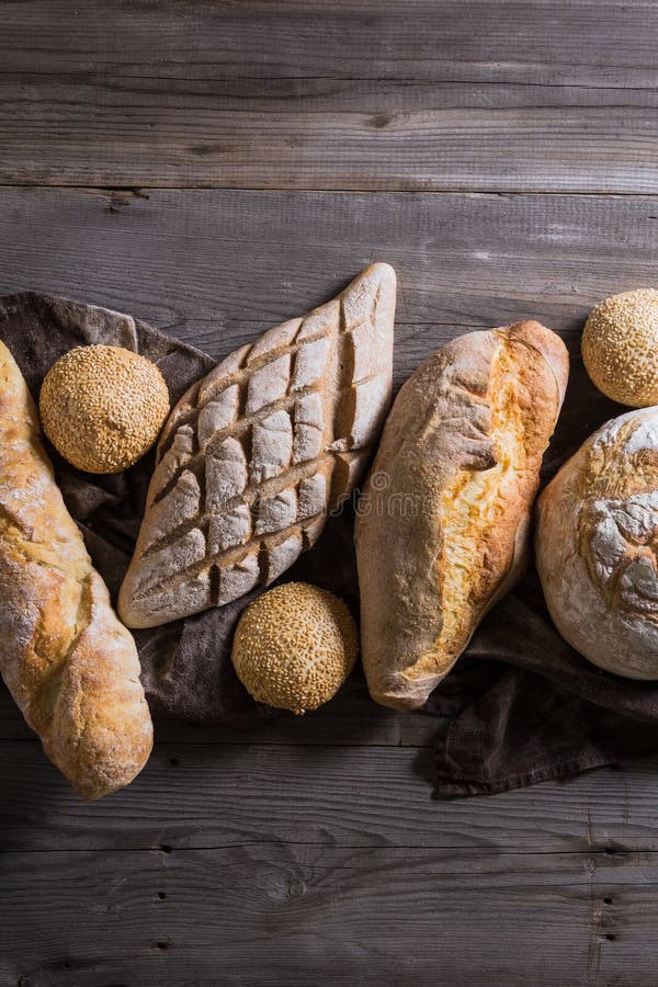 Einige Arten frisches Brot liegend auf einem alten Holztisch stockbilder Einige Arten frisches Brot liegend auf einem alten Holztisch stockbilder
