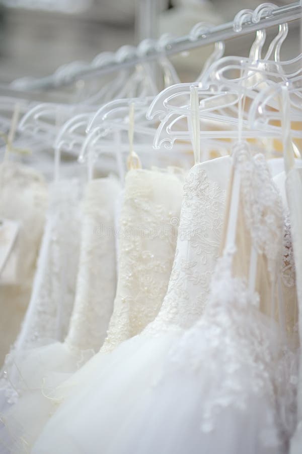 A few beautiful wedding dresses on a hanger. A few beautiful wedding dresses on a hanger