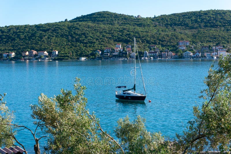 Einsames Bootssegeln in der Bucht von Kotor, Montenegro Ansicht des einsamen Bootes in den Hintergrundbergen stockbilder Einsames Bootssegeln in der Bucht von Kotor, Montenegro Ansicht des einsamen Bootes in den Hintergrundbergen stockbilder