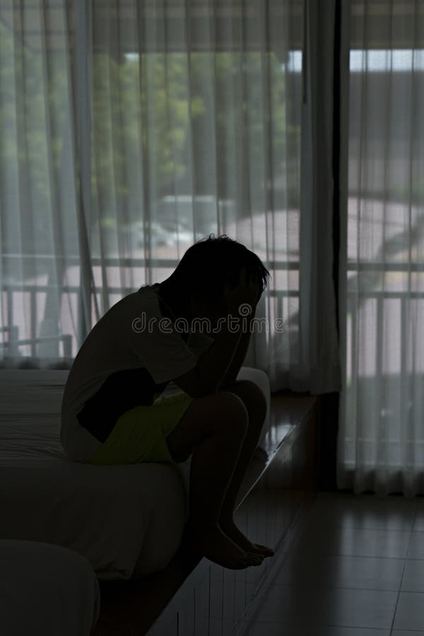 Einsames Jungengefühl traurig im Schlafzimmer stockfotografie Einsames Jungengefühl traurig im Schlafzimmer stockfotografie