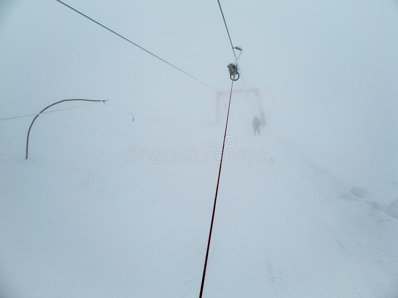 Eisiger Skiaufzug mit unerfahrenem Skifahrer herein im starken Nebel Skifahrer im Nebel auf einem schneebedeckten Berg lizenzfreie stockfotografie Eisiger Skiaufzug mit unerfahrenem Skifahrer herein im starken Nebel Skifahrer im Nebel auf einem schneebedeckten Berg lizenzfreie stockfotografie