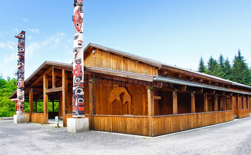 Two beautiful totem poles mark the front entrance of the Icy Strait Point Huna Tlinget Cultural Center Theater near Hoonah, Alaska on Chichagof Island. The theater is a replica of a traditional Huna community house, where extended families would gather and live. Icy Strait Point itself is owned by local native Huna Tlingit tribe members, and Hoonah is the largest Tlingit community in the Pacific Northwest. Two beautiful totem poles mark the front entrance of the Icy Strait Point Huna Tlinget Cultural Center Theater near Hoonah, Alaska on Chichagof Island. The theater is a replica of a traditional Huna community house, where extended families would gather and live. Icy Strait Point itself is owned by local native Huna Tlingit tribe members, and Hoonah is the largest Tlingit community in the Pacific Northwest.