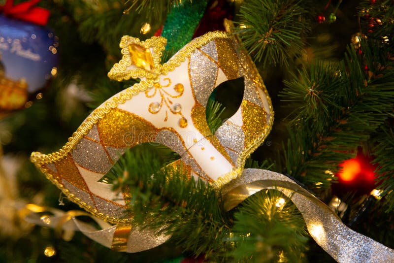 Ejecución hermosa de la máscara del carnaval en el árbol de navidad en el fondo de las decoraciones brillantes de Christmass fotografía de archivo Ejecución hermosa de la máscara del carnaval en el árbol de navidad en el fondo de las decoraciones brillantes de Christmass fotografía de archivo