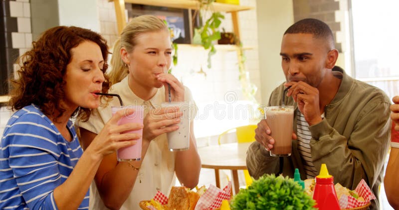 Ejecutivos felices que comen el batido de leche 4k