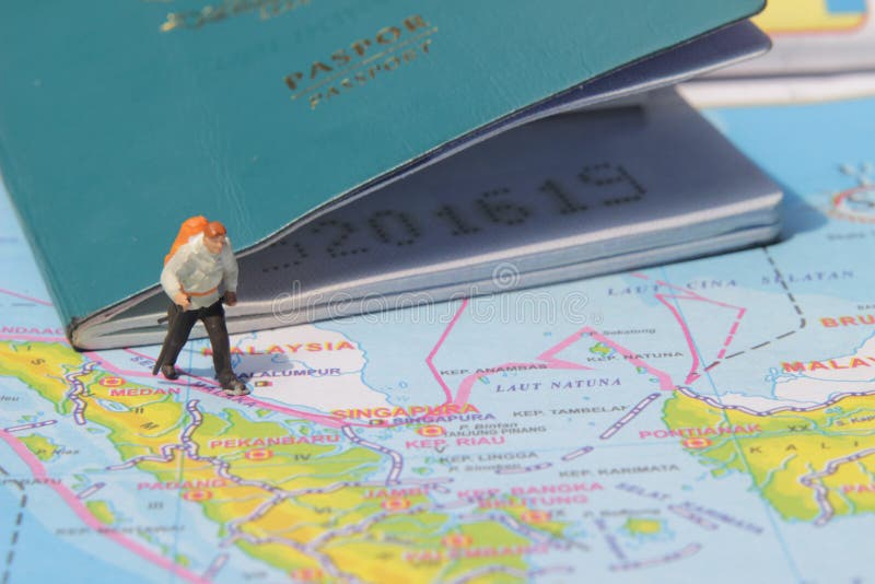 Ejemplo para el día de fiesta de la aventura, Mini Figure Hiker que camina en el atlas, pasando por el pasaporte grande fotografía de archivo libre de regalías Ejemplo para el día de fiesta de la aventura, Mini Figure Hiker que camina en el atlas, pasando por el pasaporte grande fotografía de archivo libre de regalías