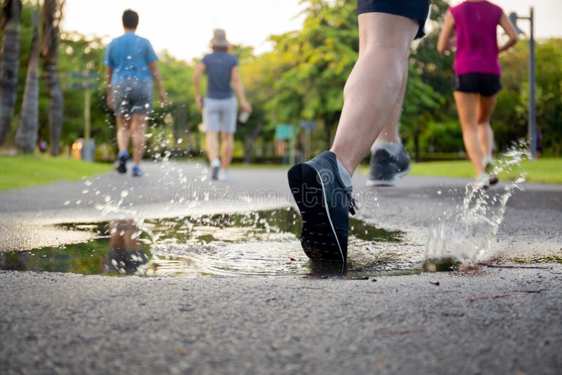Ejercicio del hombre que corre a trav? s del charco que salpica sus zapatos fotografía de archivo libre de regalías