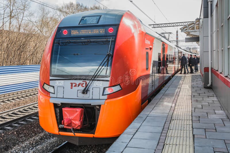 Ekaterinburg, Sverdlovsk Russia - 24 04 2019: Il nuovo treno elettrico rosso ed arancio Lastochka è arrivato ad una nuova stazion fotografie stock libere da diritti Ekaterinburg, Sverdlovsk Russia - 24 04 2019: Il nuovo treno elettrico rosso ed arancio Lastochka è arrivato ad una nuova stazion fotografie stock libere da diritti