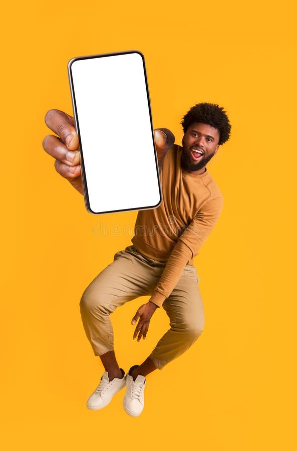 Ekscytowany czarny facet trzymający smartfona podskakujący