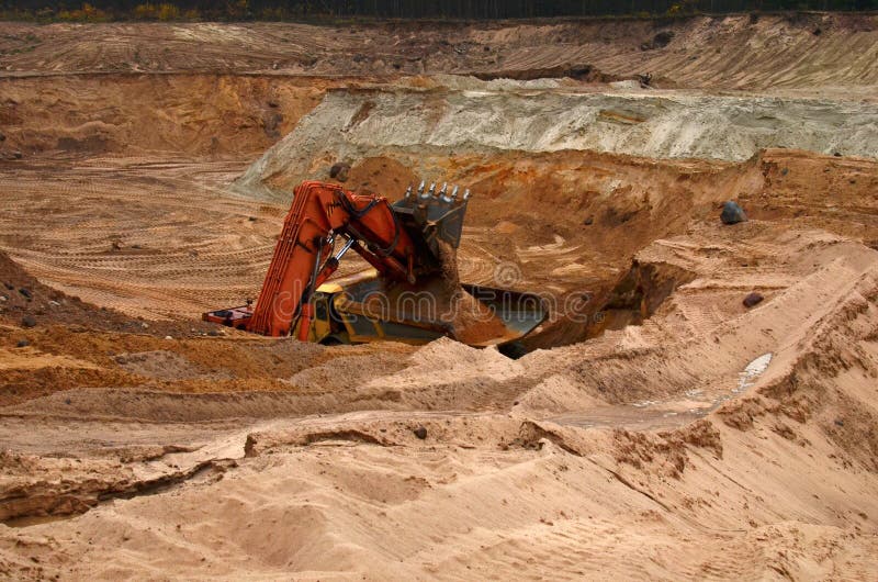 Excavator loading sand into dumper truck. Quarry for the extraction of minerals. Excavator loading sand into dumper truck. Quarry for the extraction of minerals