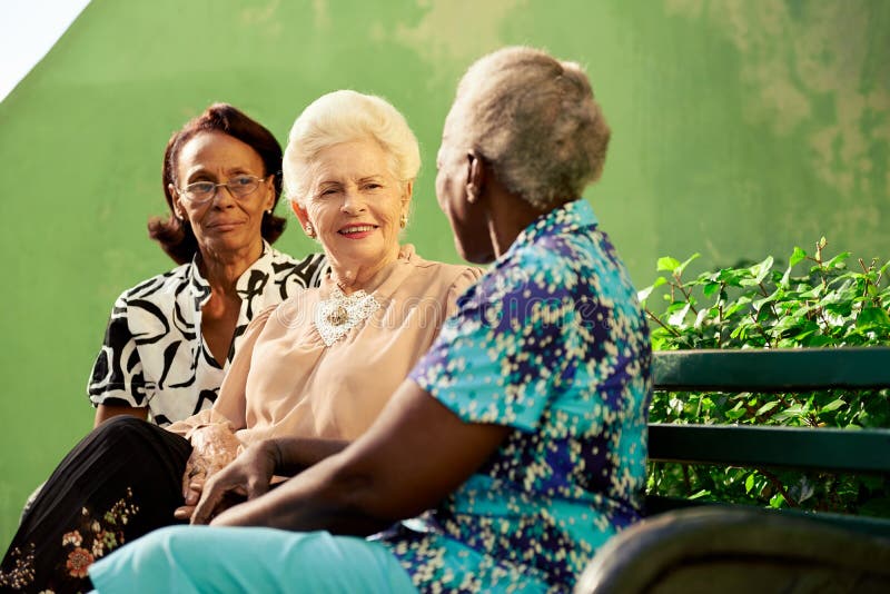 Grupo de mujeres negras y caucásicas mayores que hablan en parque imagen de archivo Grupo de mujeres negras y caucásicas mayores que hablan en parque imagen de archivo