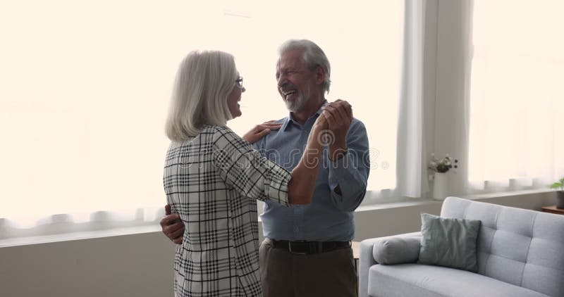 El activo y alegre marido y mujer que bailan y hablan