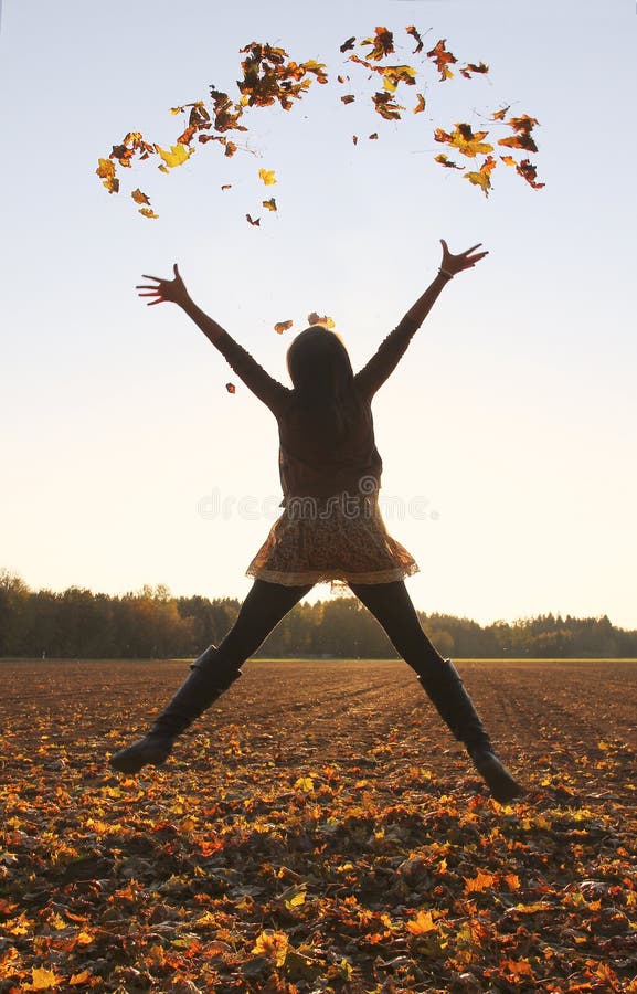 Jumping teenage girl, throwing leaves up in the air, autumnal fields. Jumping teenage girl, throwing leaves up in the air, autumnal fields.