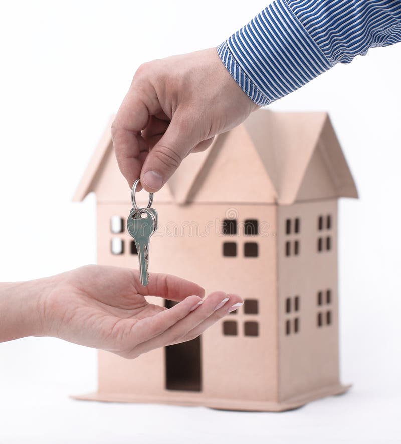 El agente inmobiliario entrega la propiedad o nuevas teclas HOME a un cliente en blanco fotografía de archivo libre de regalías El agente inmobiliario entrega la propiedad o nuevas teclas HOME a un cliente en blanco fotografía de archivo libre de regalías