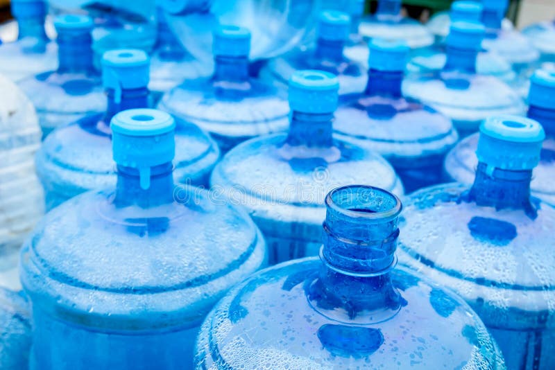 El agua potable azul grande barrels, las botellas, galón, consigue mojada en th fotos de archivo El agua potable azul grande barrels, las botellas, galón, consigue mojada en th fotos de archivo