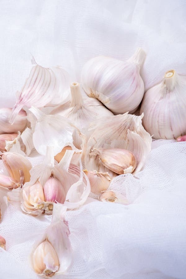El ajo, clavos de ajo, ajo descascara el primer en un fondo blanco con gasa imagenes de archivo El ajo, clavos de ajo, ajo descascara el primer en un fondo blanco con gasa imagenes de archivo