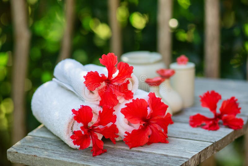 El ajuste del balneario con las toallas y el hibisco rojo florece foto de archivo El ajuste del balneario con las toallas y el hibisco rojo florece foto de archivo