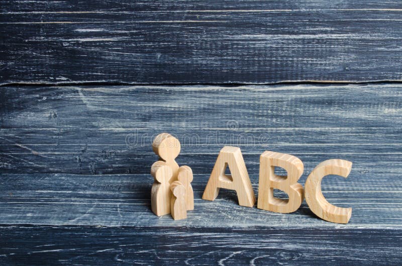 El alumno y los alumnos se colocan en las letras grandes ABC del alfabeto inglés Padre y niños El concepto de educación foto de archivo libre de regalías El alumno y los alumnos se colocan en las letras grandes ABC del alfabeto inglés Padre y niños El concepto de educación foto de archivo libre de regalías