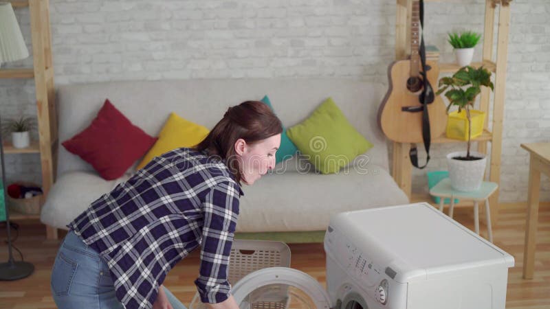 El ama de casa alegre de la mujer joven lava cosas