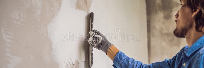 El Amo Está Aplicando La Masilla Blanca En Una Pared Y La Está Manchando  Por El Cuchillo De Masilla En Un Cuarto De Renovar La Ca Imagen de archivo  - Imagen de