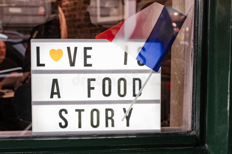 'El amor es una historia de comida' cartel en la ventana de un restaurante imagen de archivo 'El amor es una historia de comida' cartel en la ventana de un restaurante imagen de archivo