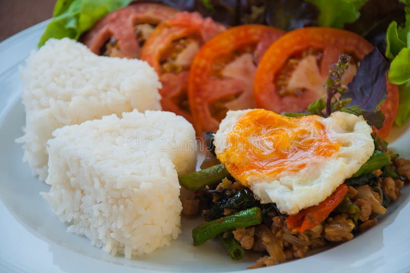 El arroz remató con cerdo y albahaca sofritos con el huevo fotografía de archivo libre de regalías El arroz remató con cerdo y albahaca sofritos con el huevo fotografía de archivo libre de regalías