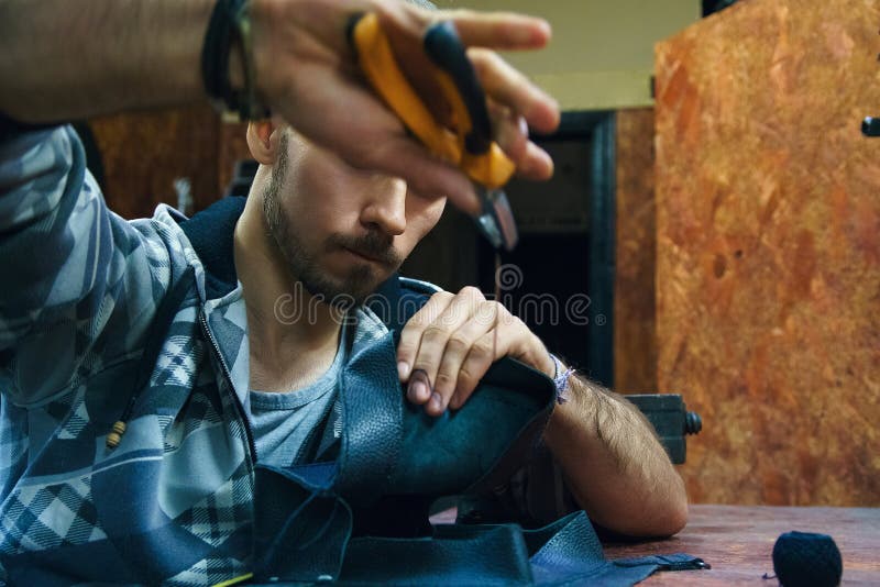 El artesano crea el bolso de cuero en taller fotografía de archivo El artesano crea el bolso de cuero en taller fotografía de archivo