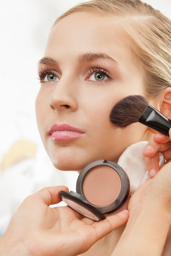 Makeup artist apply blush on cheeks with blush brush. Makeup artist apply blush on cheeks with blush brush