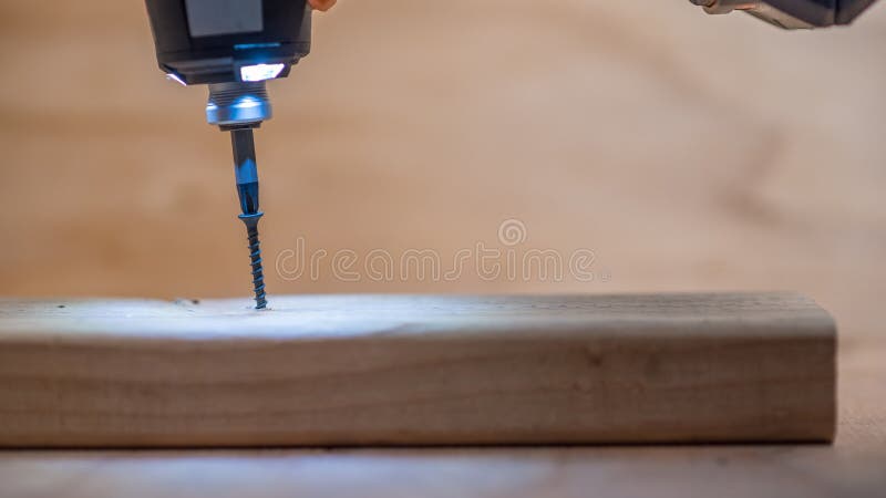 El atornillar en la madera de construcción recientemente cortada imagen de archivo libre de regalías El atornillar en la madera de construcción recientemente cortada imagen de archivo libre de regalías