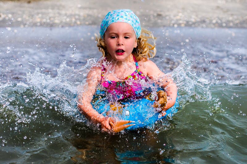 El azul observó a la niña rubia que jugaba en el agua imágenes de archivo libres de regalías El azul observó a la niña rubia que jugaba en el agua imágenes de archivo libres de regalías