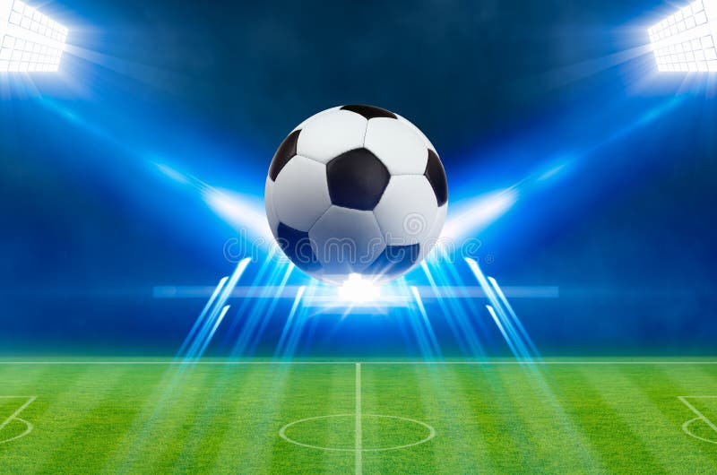 El balón de fútbol, proyectores brillantes, ilumina el estadio de fútbol verde libre illustration El balón de fútbol, proyectores brillantes, ilumina el estadio de fútbol verde libre illustration