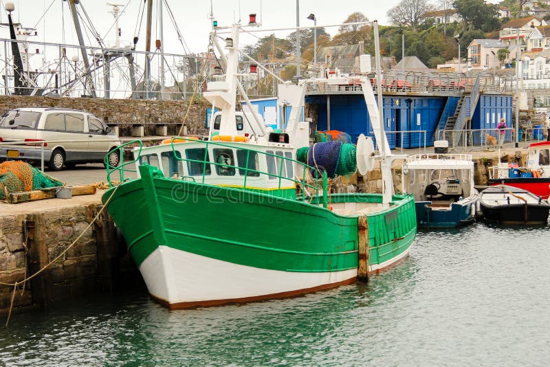 El barco rastreador pesquero verde amarró longside la pared del puerto, Brixham, Devon del sur fotos de archivo El barco rastreador pesquero verde amarró longside la pared del puerto, Brixham, Devon del sur fotos de archivo