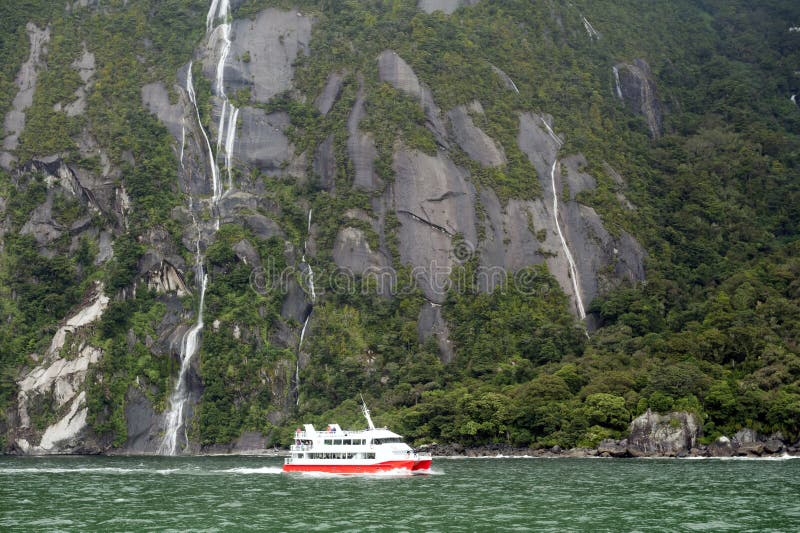 El barco turístico cruza en el fiordo de Milford Sound, isla del sur de Nueva Zelanda fotografía de archivo El barco turístico cruza en el fiordo de Milford Sound, isla del sur de Nueva Zelanda fotografía de archivo