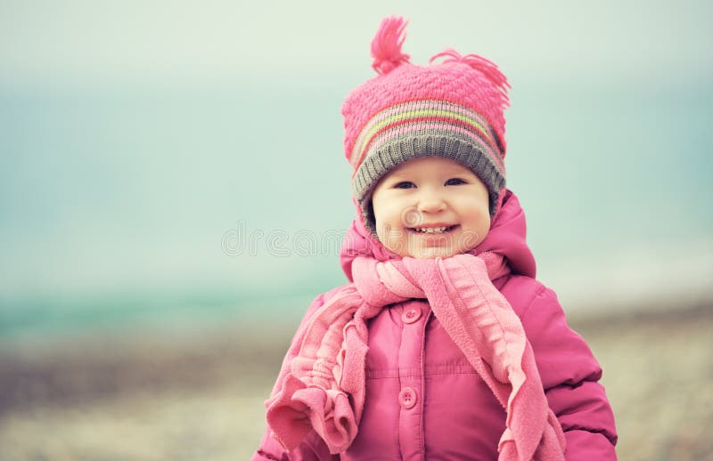 El bebé feliz en sombrero y bufanda rosados ríe imágenes de archivo libres de regalías El bebé feliz en sombrero y bufanda rosados ríe imágenes de archivo libres de regalías