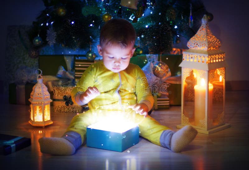 El bebé lindo abrió la caja de regalo mágica debajo de árbol de Navidad fotos de archivo libres de regalías El bebé lindo abrió la caja de regalo mágica debajo de árbol de Navidad fotos de archivo libres de regalías