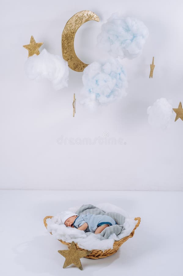 el bebé recién nacido adorable que duerme en cesta con las nubes decorativas está en la luna y las estrellas fotografía de archivo libre de regalías el bebé recién nacido adorable que duerme en cesta con las nubes decorativas está en la luna y las estrellas fotografía de archivo libre de regalías