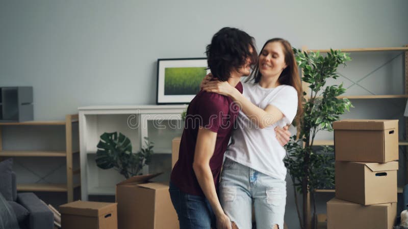 El besarse de baile de amor del marido y de la esposa divirtiéndose en casa durante la relocalización