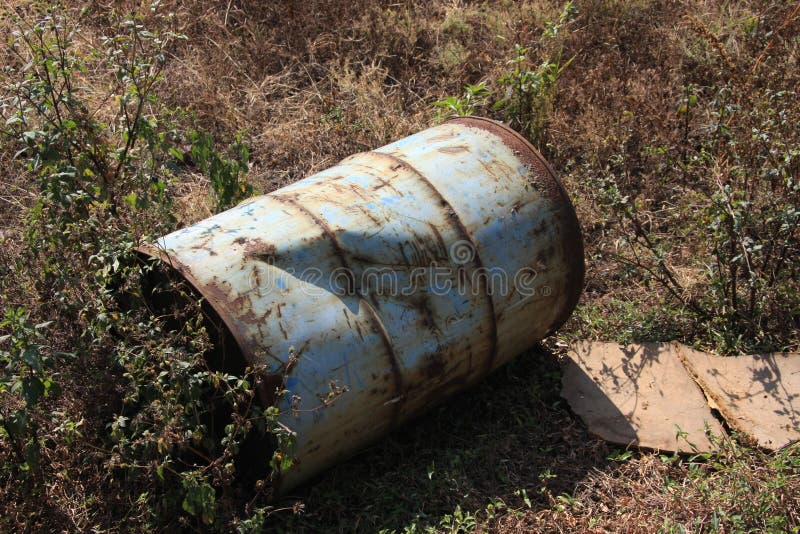 El bidón de aceite/el barril viejos se fue dañado en la tierra imagen de archivo El bidón de aceite/el barril viejos se fue dañado en la tierra imagen de archivo