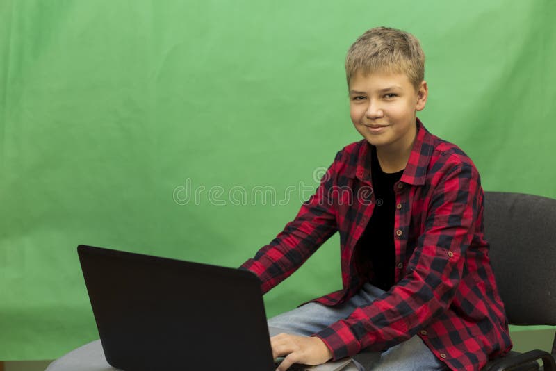 El blogger joven del muchacho registra el vídeo en un fondo verde imagen de archivo libre de regalías El blogger joven del muchacho registra el vídeo en un fondo verde imagen de archivo libre de regalías